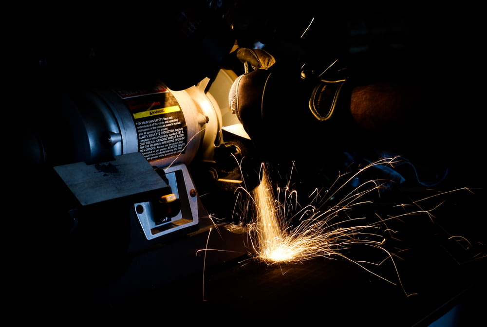 person using bench grinder
