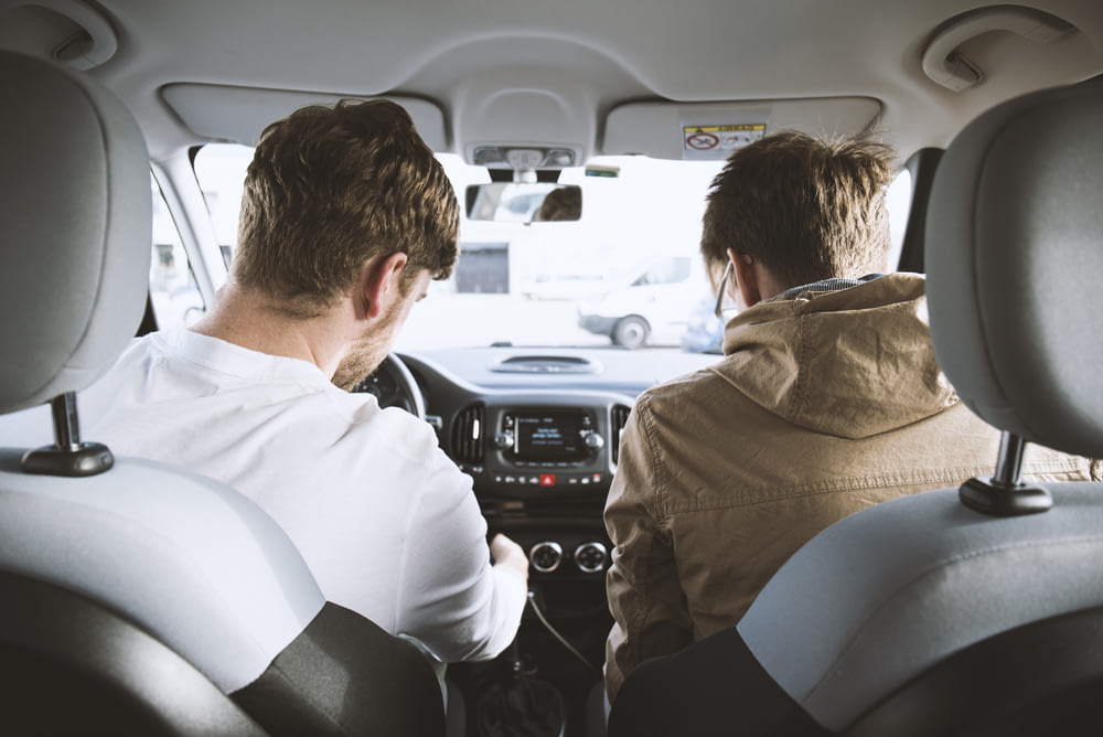 deux hommes assis à l’intérieur d’un véhicule