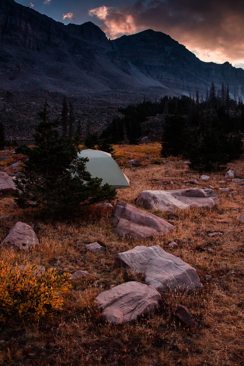 white camping tent near mountain during daytime