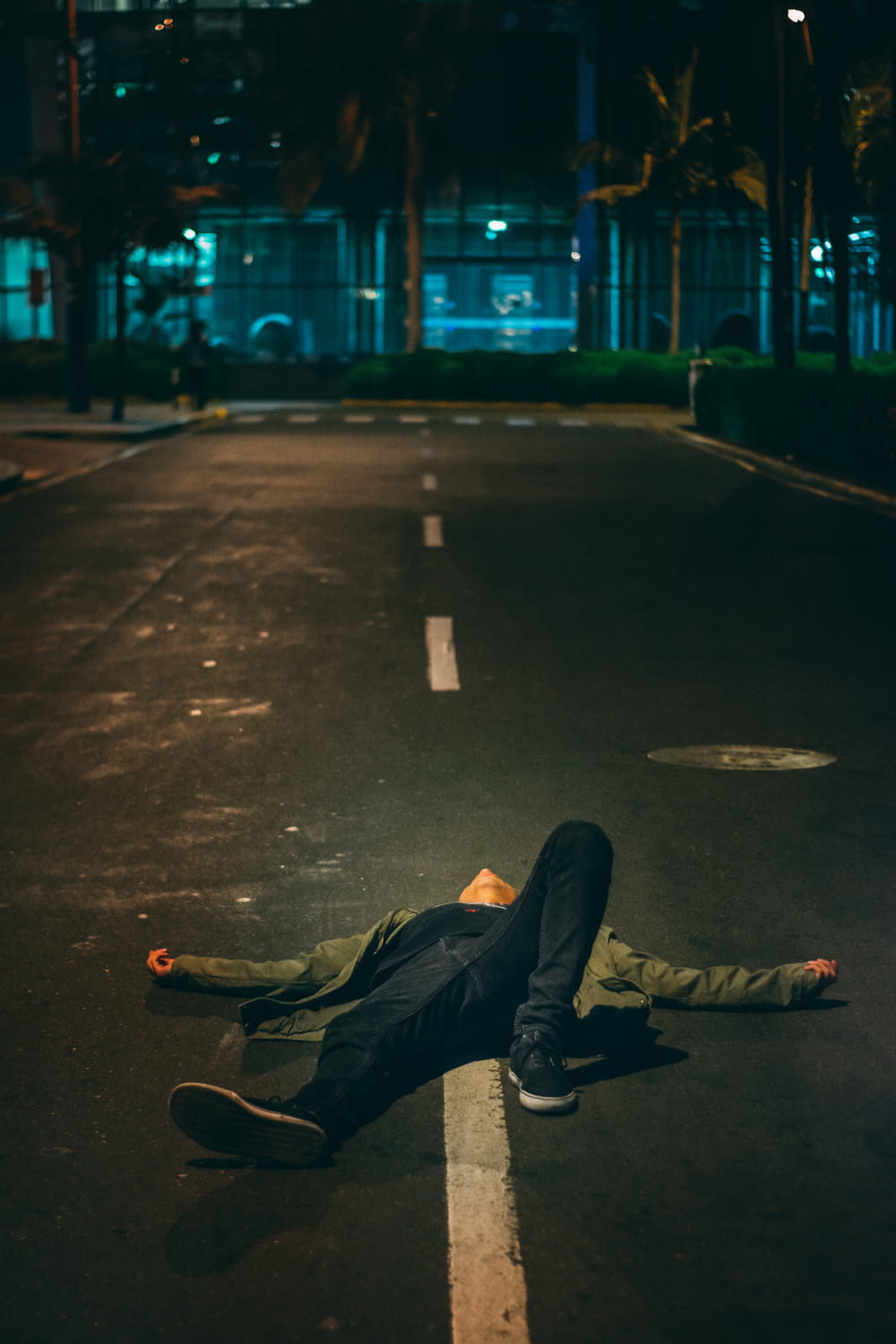 Mann legt sich nachts auf die Straße