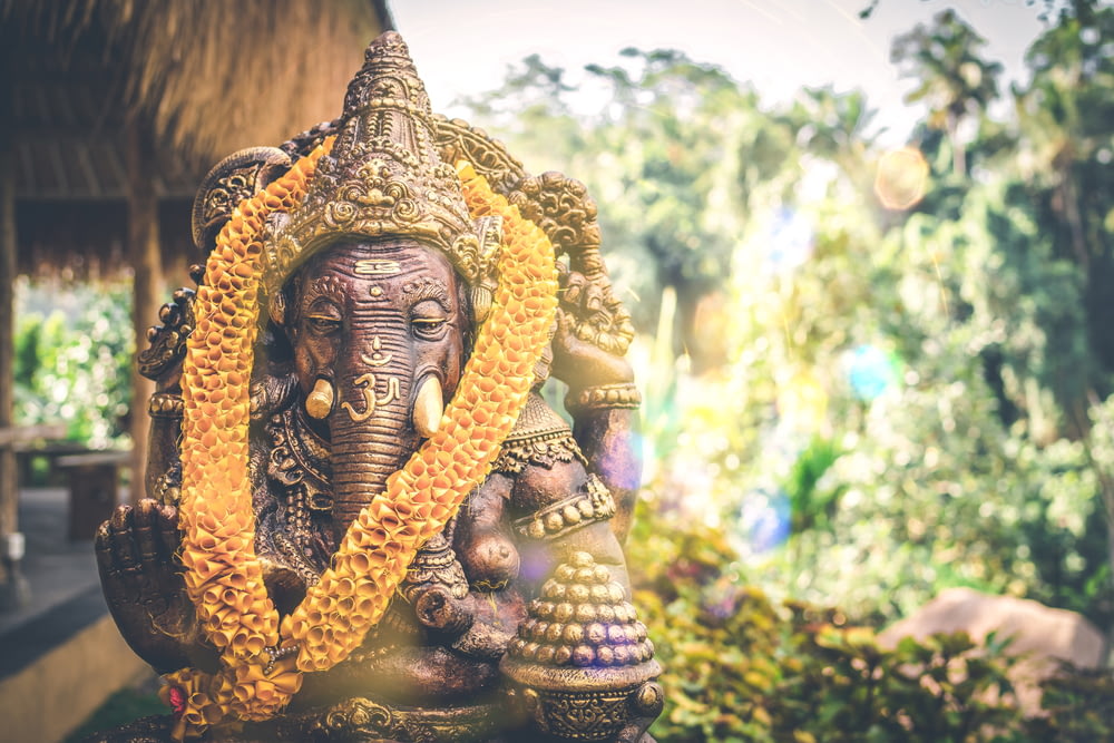 fotografia de foco seletivo da estátua dourada da divindade hindu do Senhor Ganesha