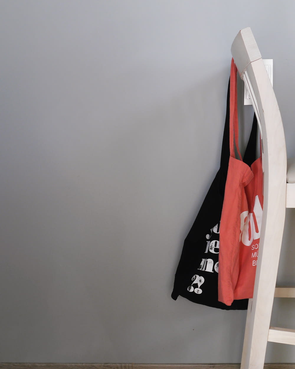 two red and black tote bags hanged on rack