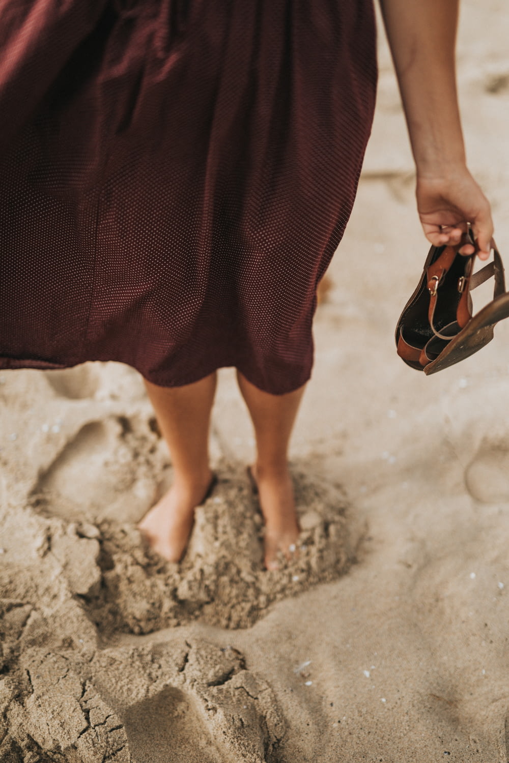 woman stepping on brown sand