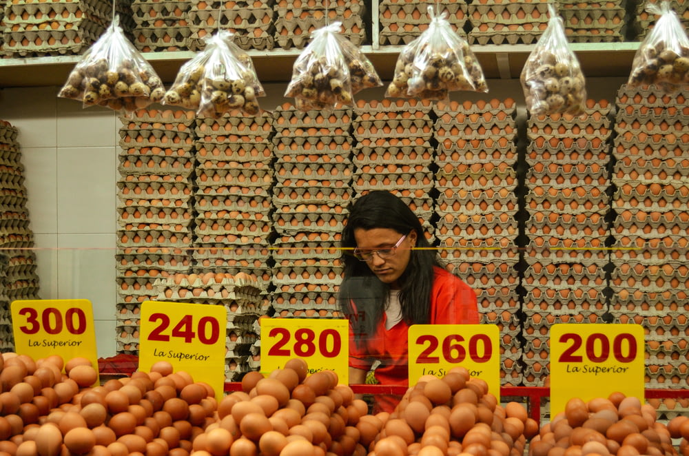 woman wearing red shirt standing beside display food