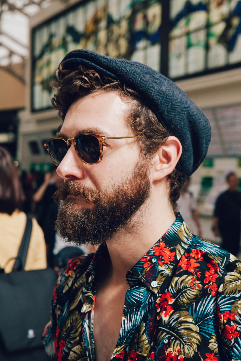 man wearing multicolored floral shirt and black framed black lens sunglasses