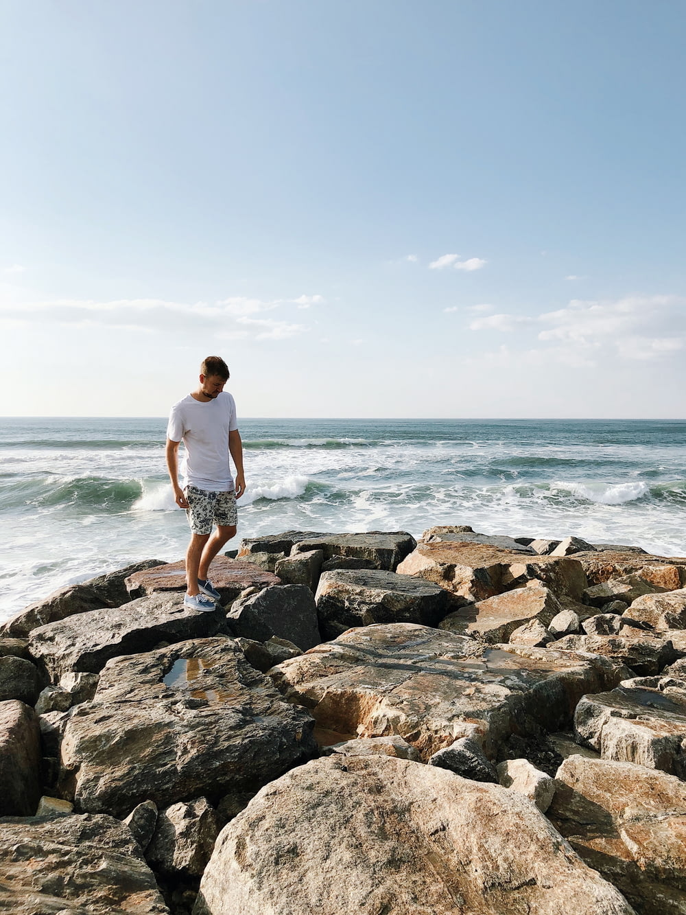 Homme debout sur des rochers près d’un plan d’eau