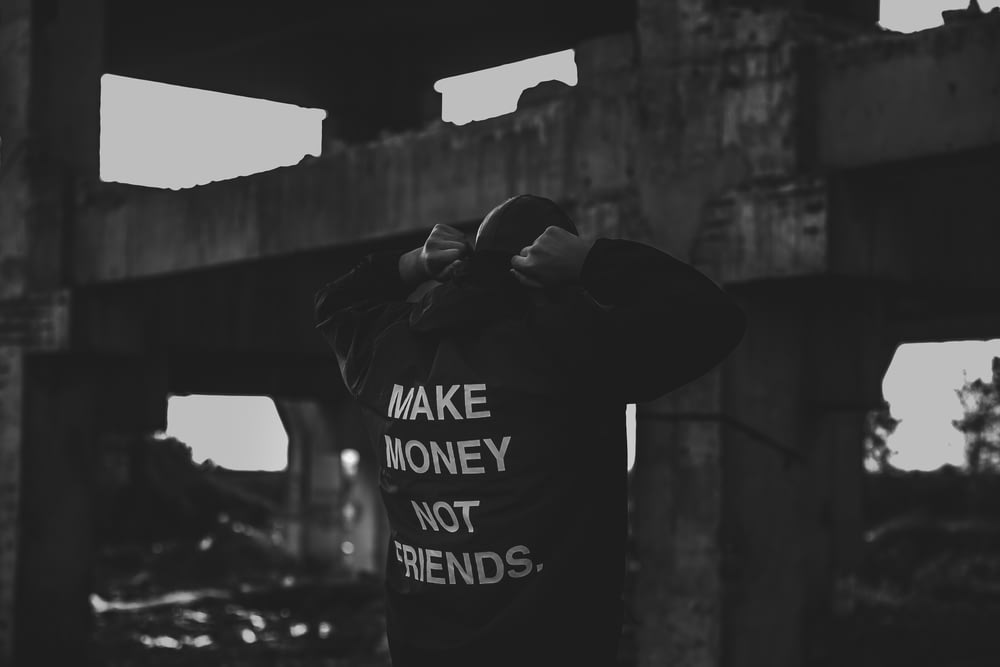 person wearing black and white make money not friends printed jacket