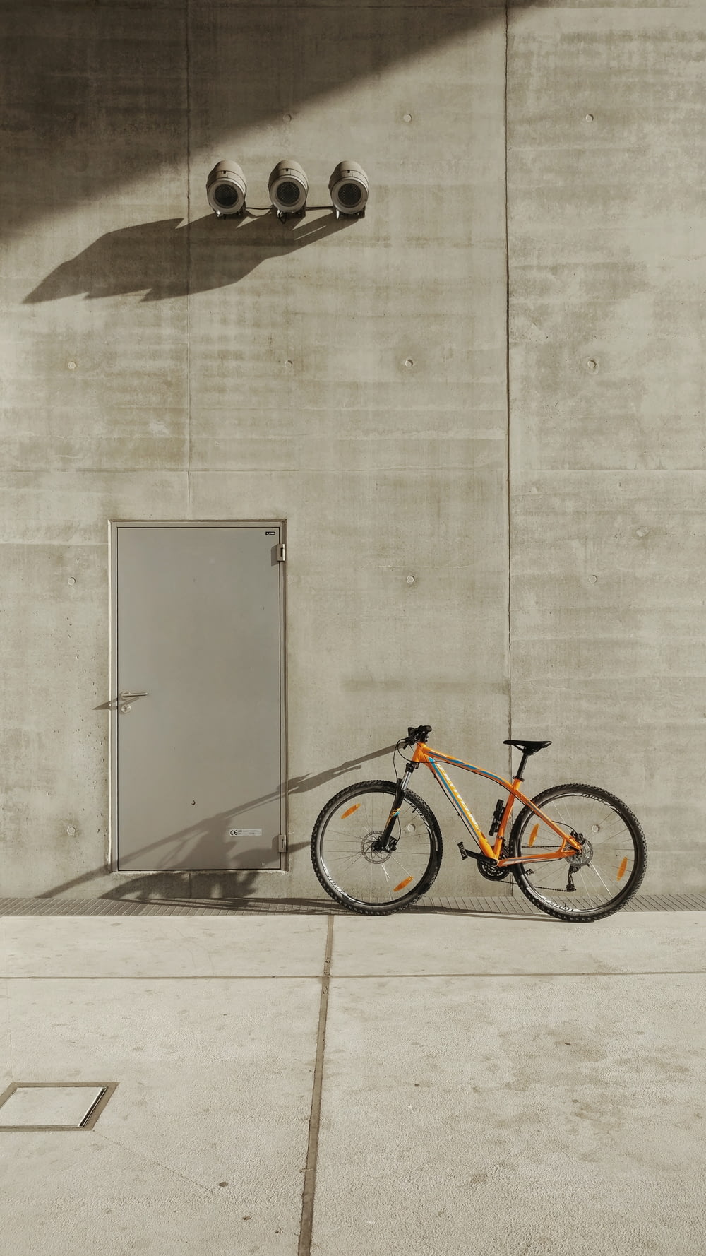orange mountain bike beside wall