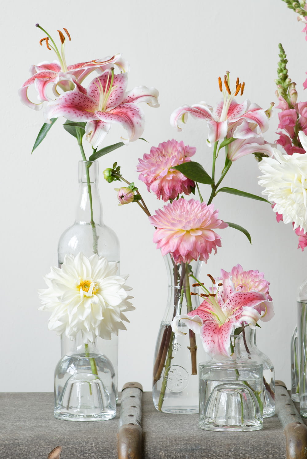 green-leafed plants with pink flowers in clear glass vase