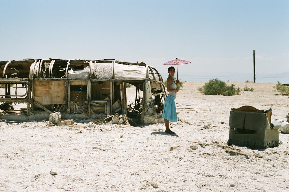 femme debout à côté d’un bus abandonné