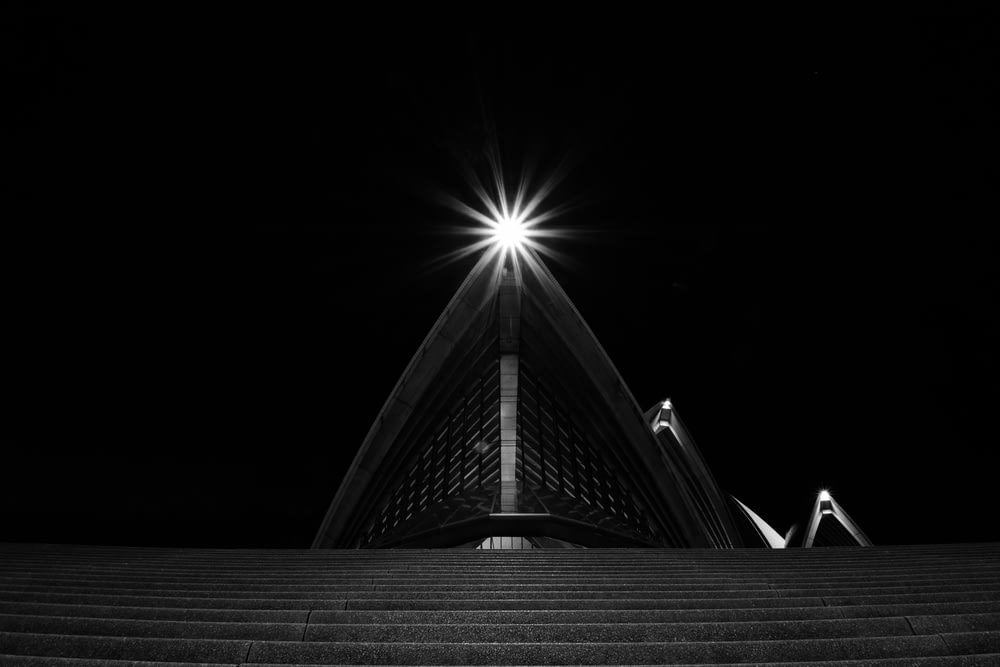 a black and white photo of a stairway at night