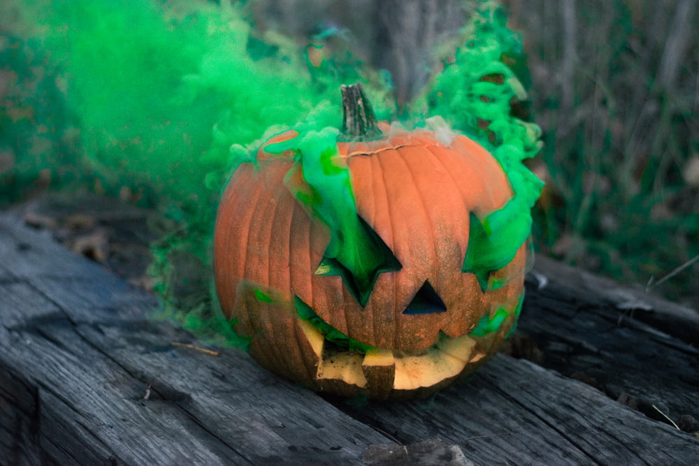Jack-o'-lantern liberando fumaça verde em placa de madeira cinza