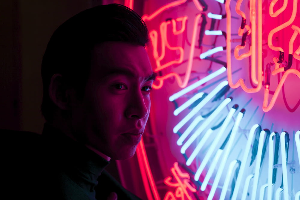 man standing near neon signage light