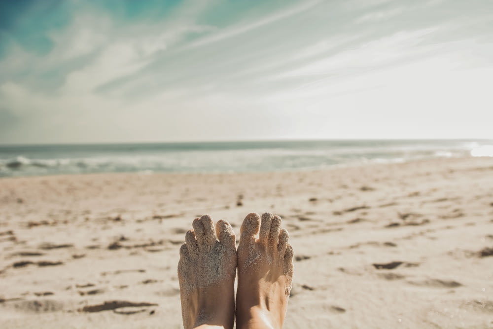 Mit Sand bedeckte Füße