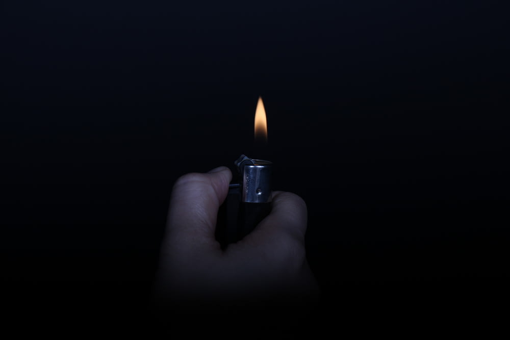 person holding lighted lighter