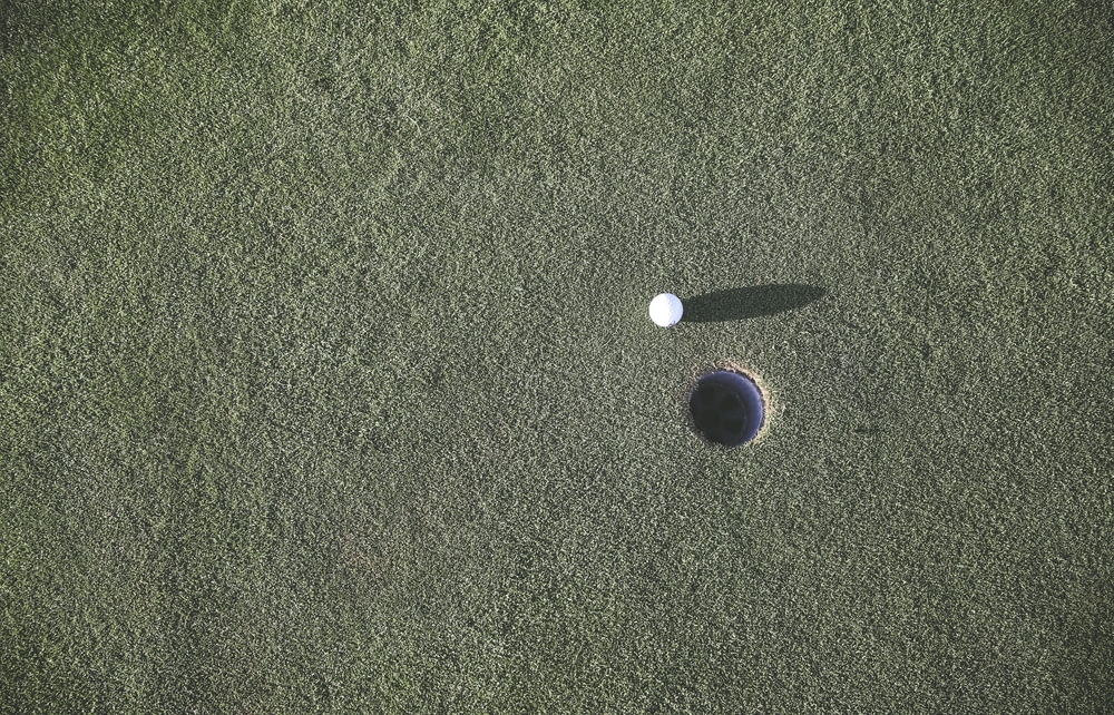 white golf ball near hole
