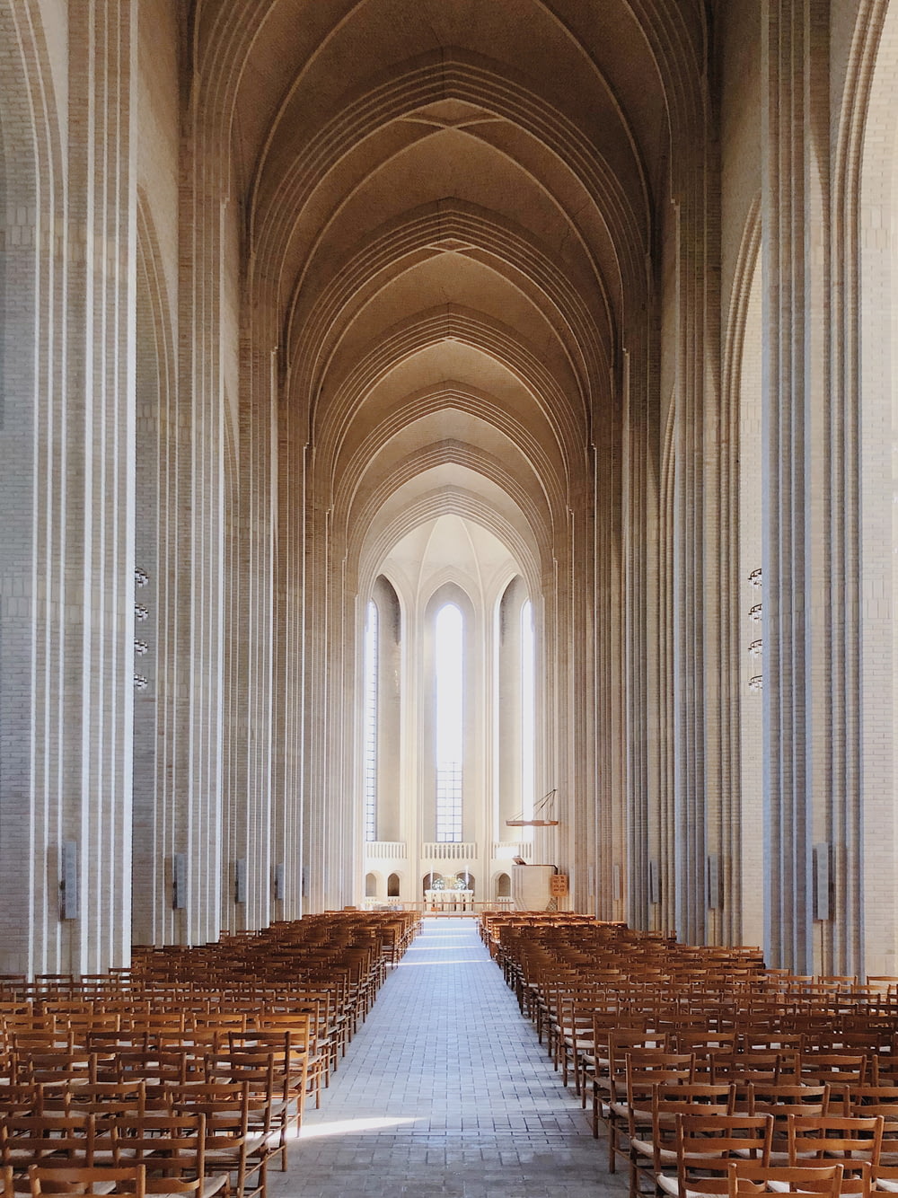 une grande cathédrale avec des rangées de chaises en bois