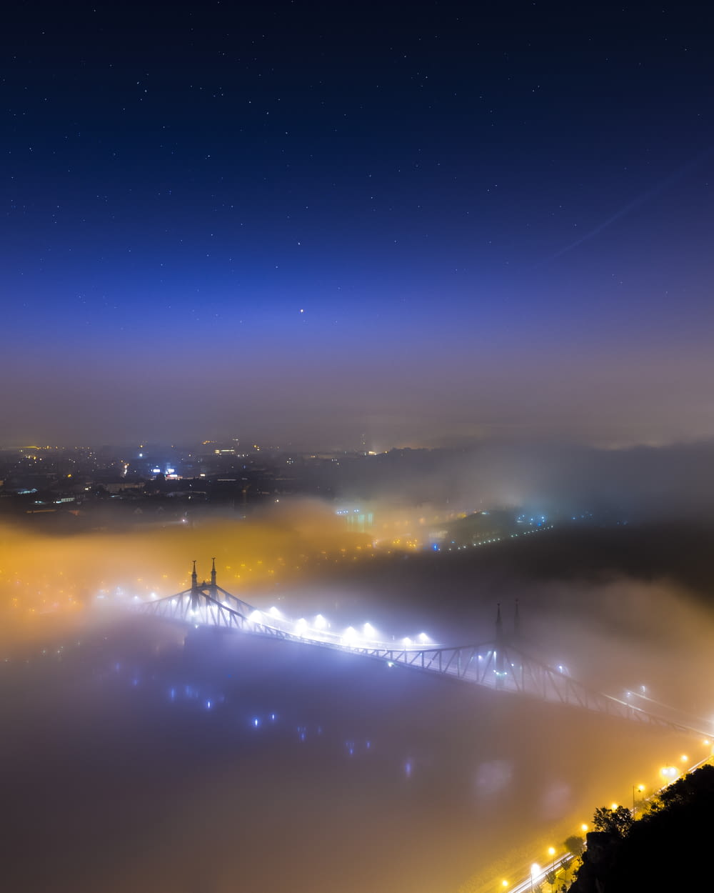 bridge covered with fog during nighttime