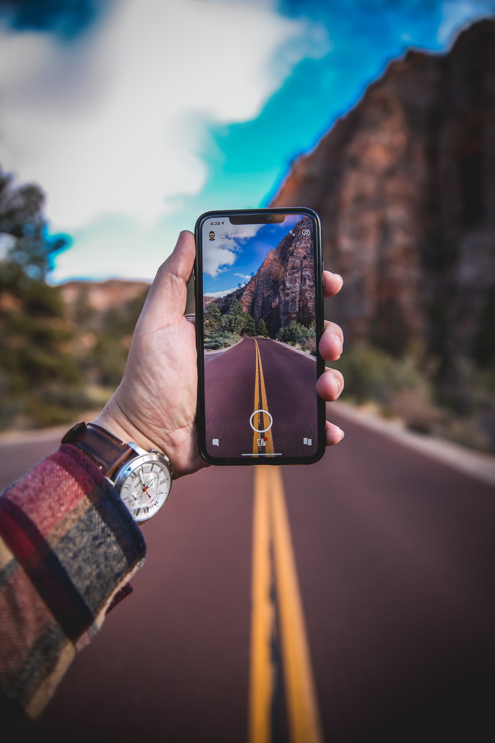 person holding smartphone with empty road photo