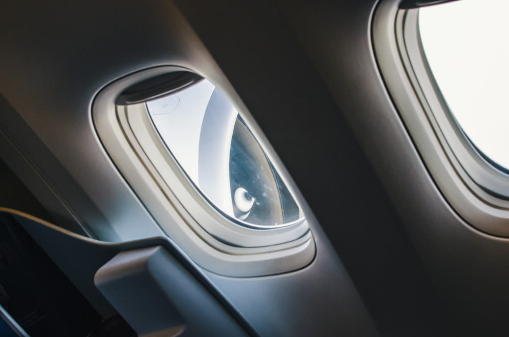 an airplane window with a person looking out the window