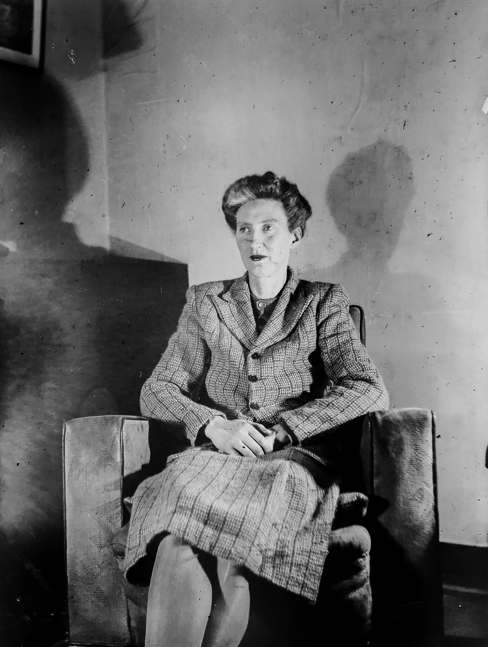 Graustufenfotografie einer Frau, die auf einem Stuhl sitzt