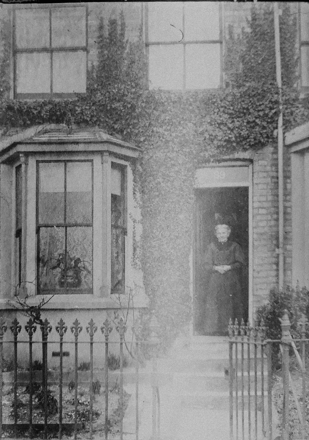 Graustufenfoto von 2 Frauen, die vor dem Fenster stehen