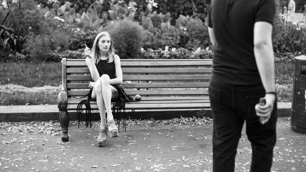 Fotografía en escala de grises de mujer sentada cerca de hombre