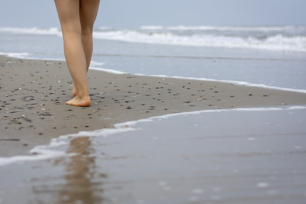 person's leg walking on beach