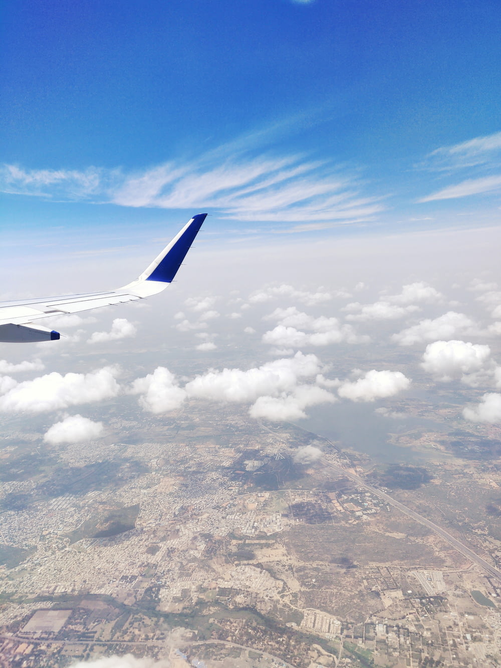 plane view of white and blue sky and land below