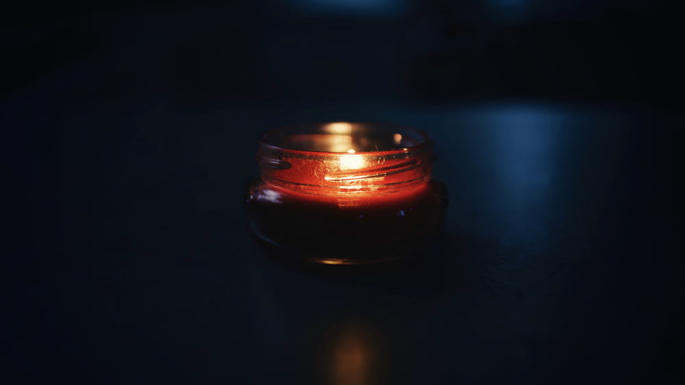 vela votiva preta e vermelha com chama
