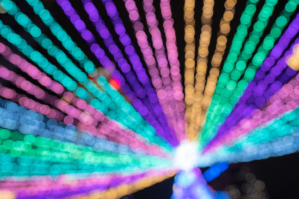 a close up of a colorful ferris wheel at night