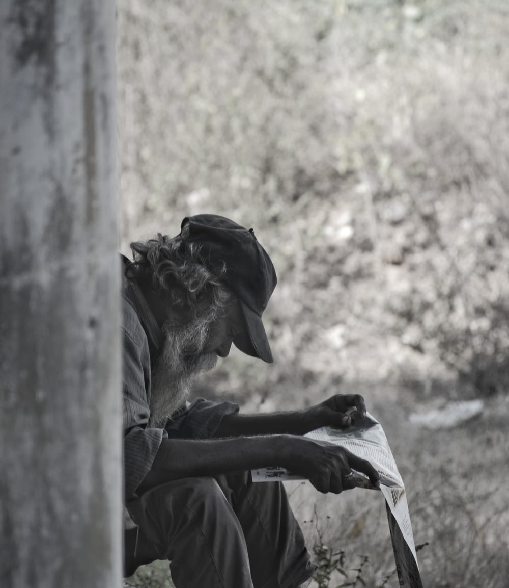 man reading grayscale photography