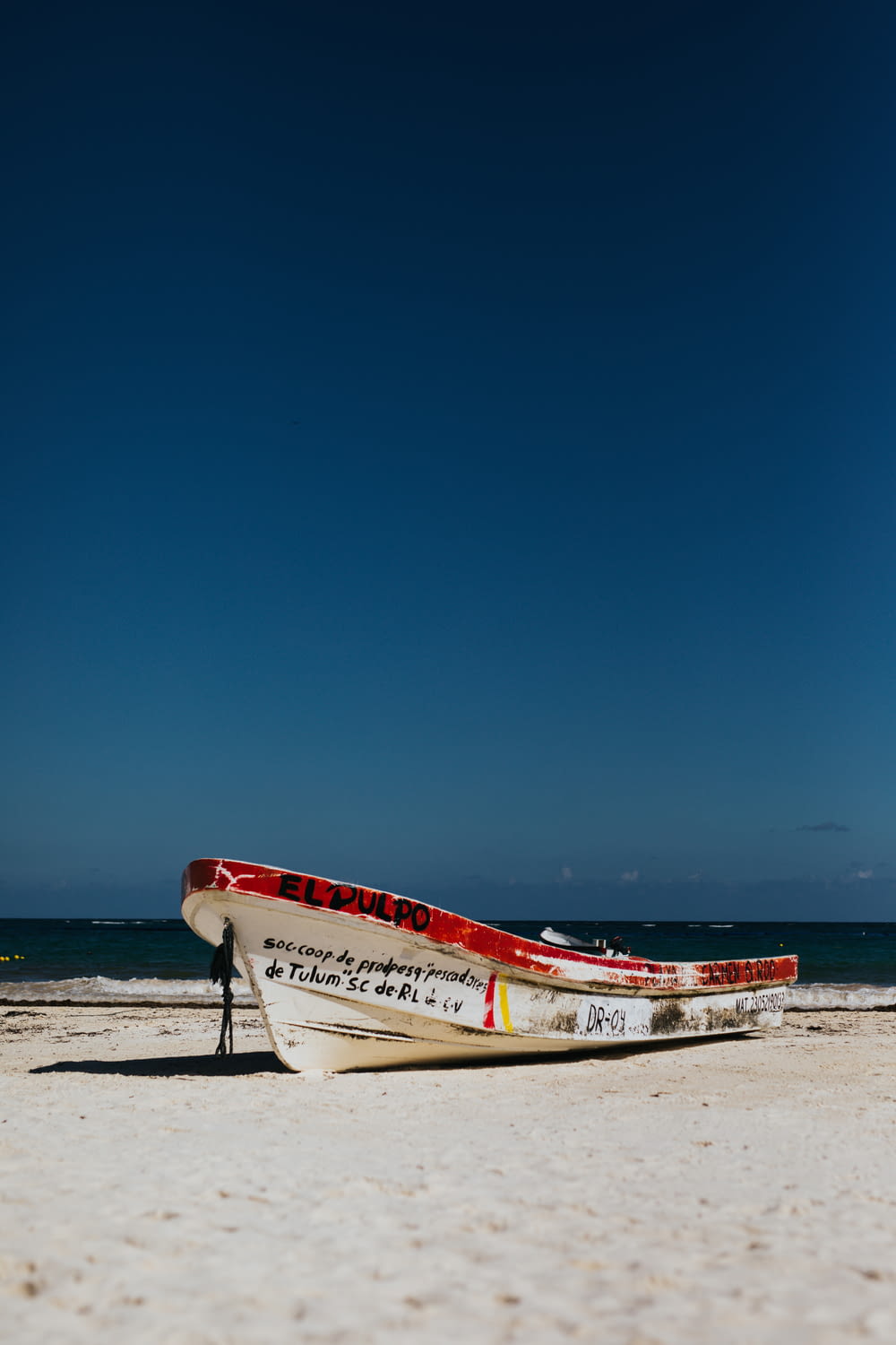 white and red boat near ocean