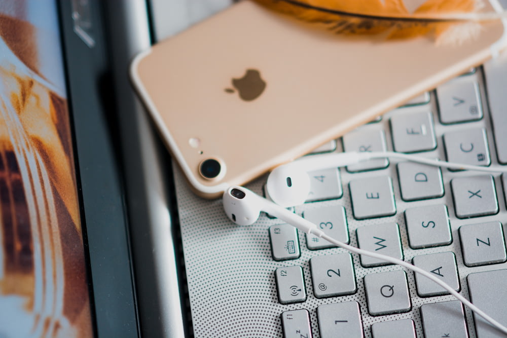 gold iPhone 7 on grey laptop