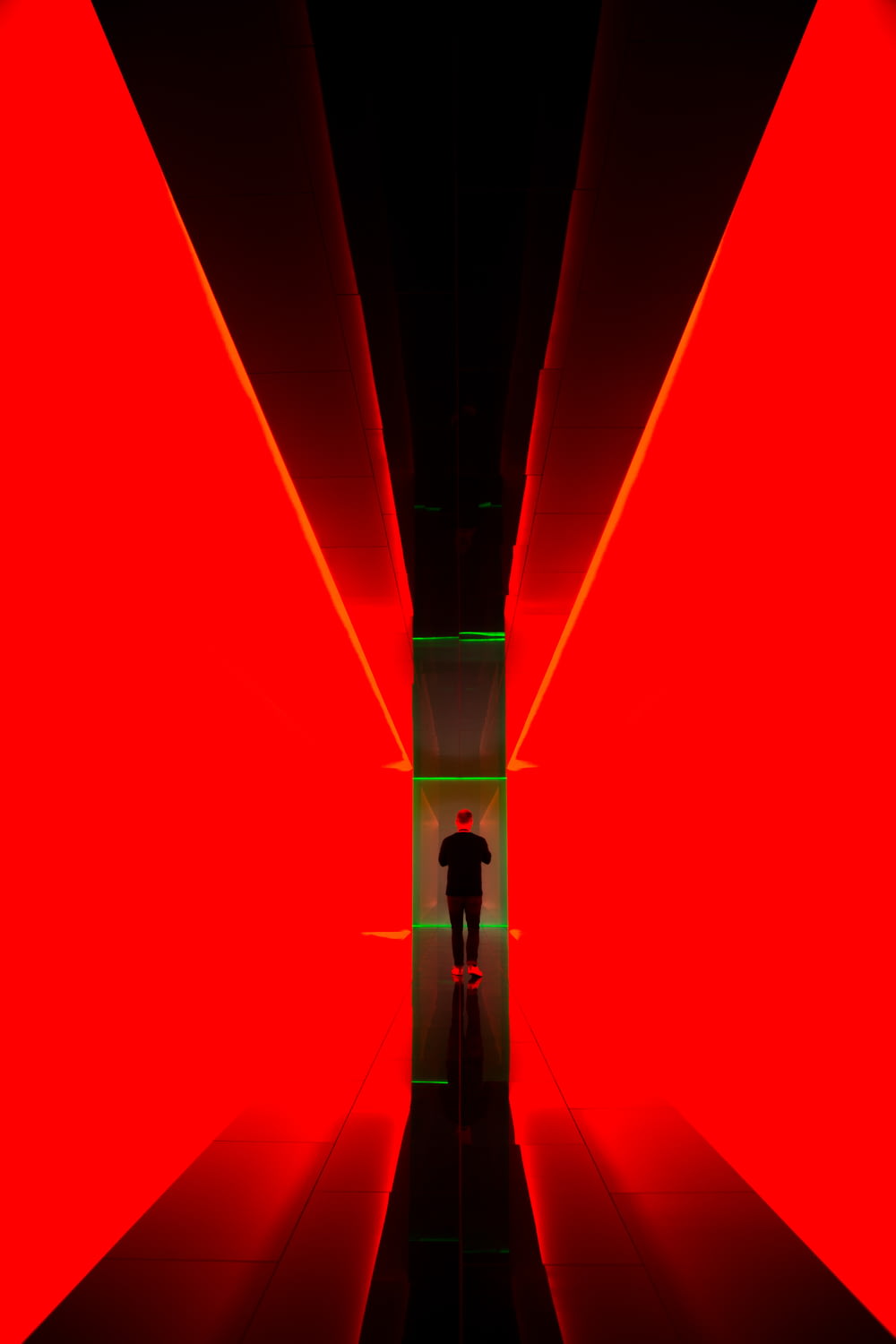 man between red light hallway