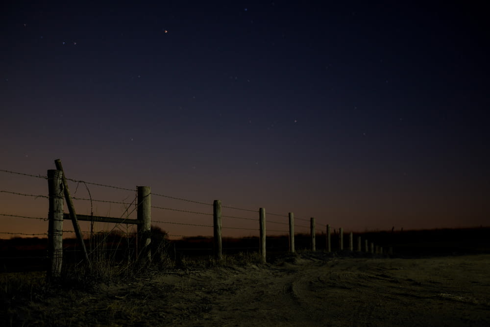 夜間のポールと鉄条網の風景写真