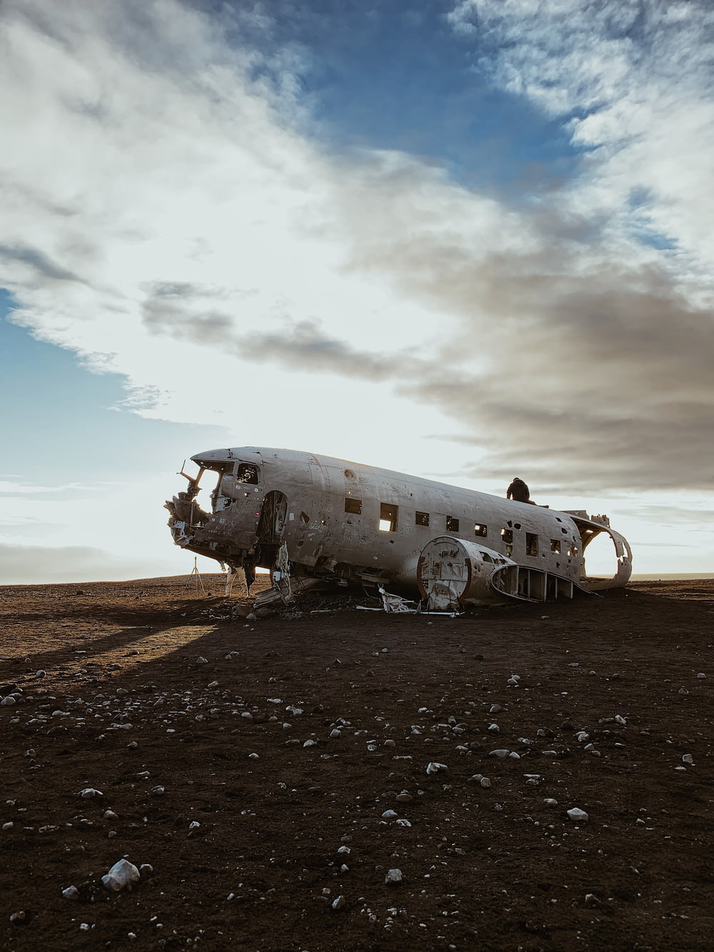 wrecked and abandoned airplane on dirt field