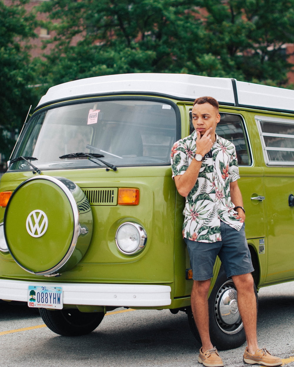 man leaning on green Volkswagen vehicle