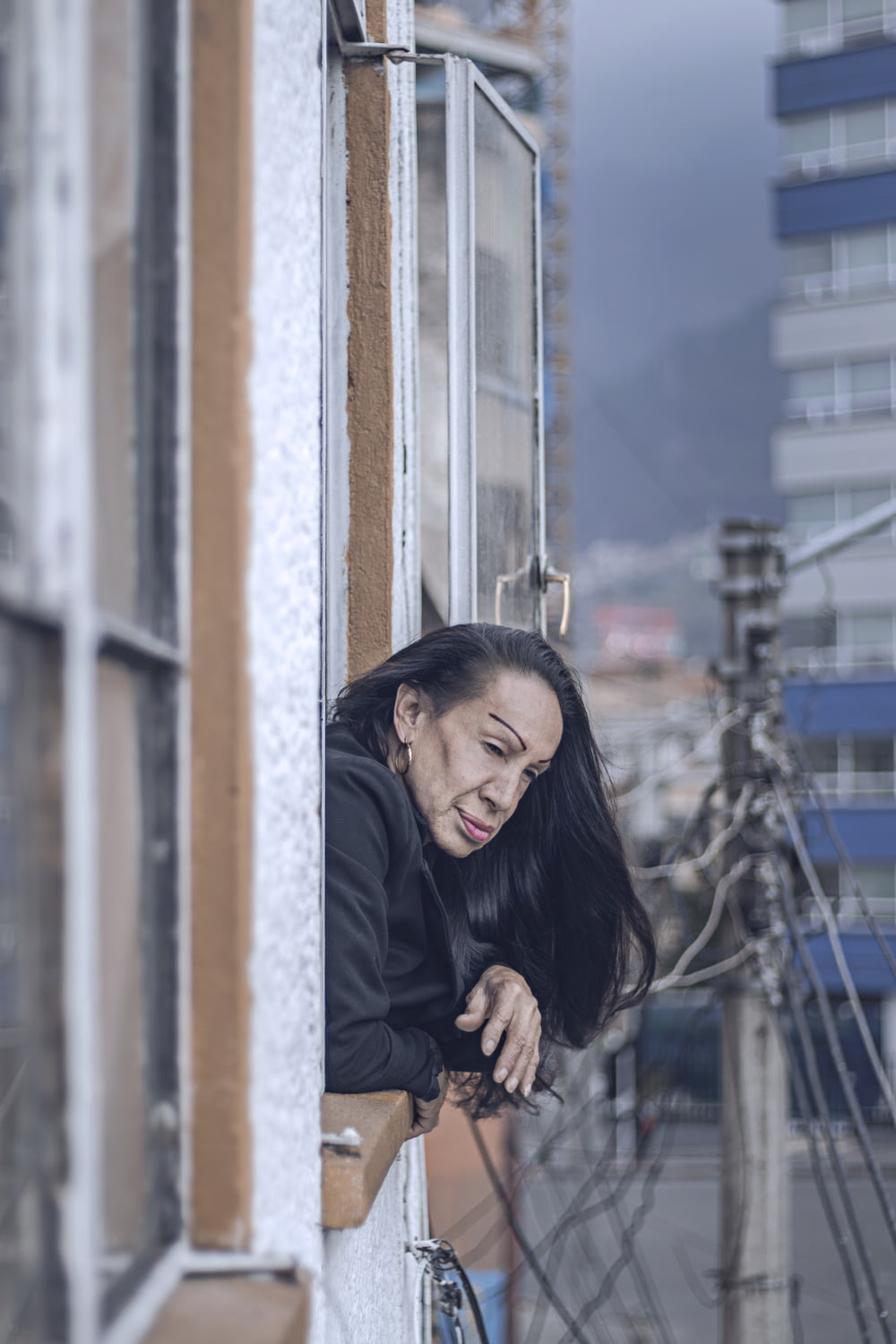 woman in black top leaning on window