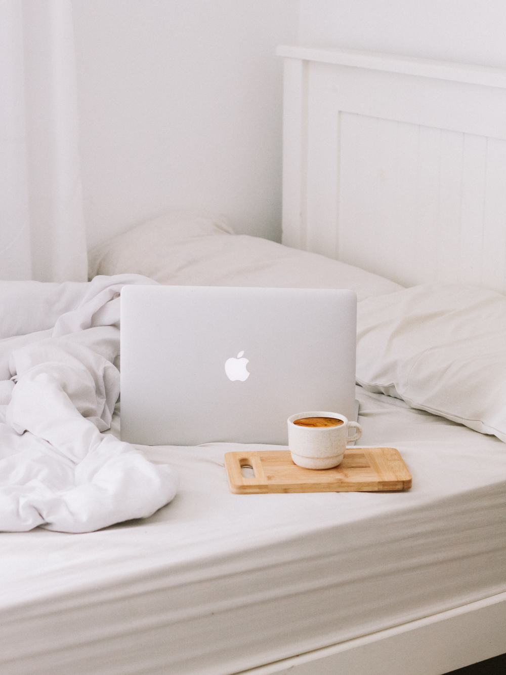 MacBook accanto a tazza da tè con latte