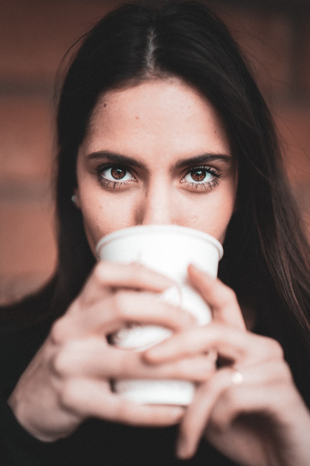 woman holding white disposable cup