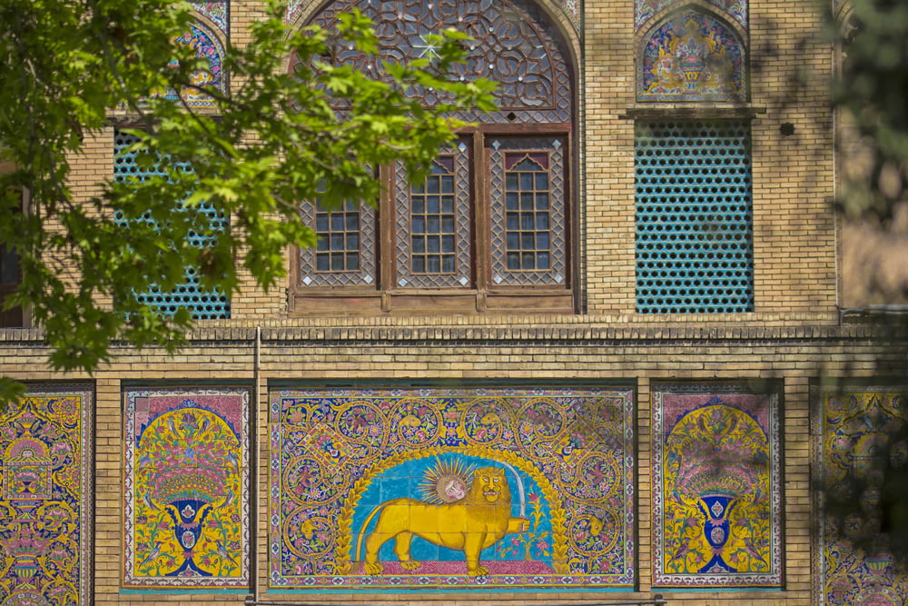 multicolored lion art on building's wall at daytime