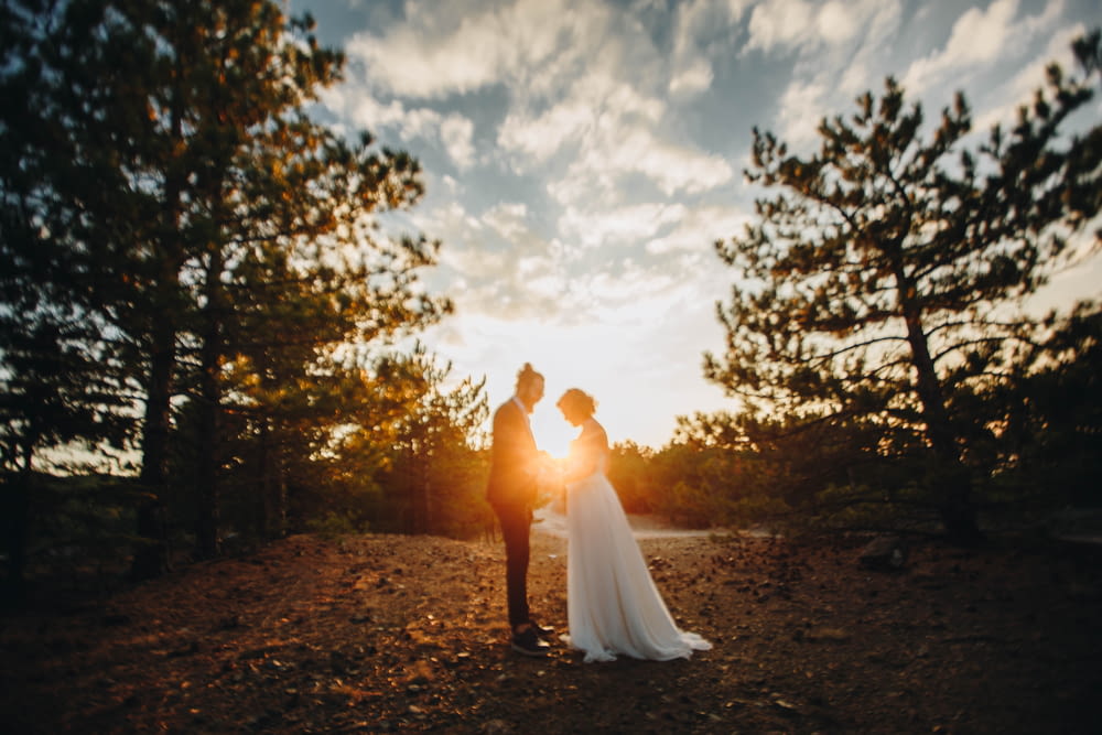 standing newly wed couple near trees during golden hour