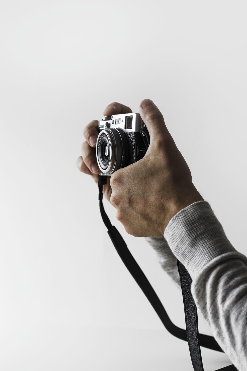 person holding gray and black camera