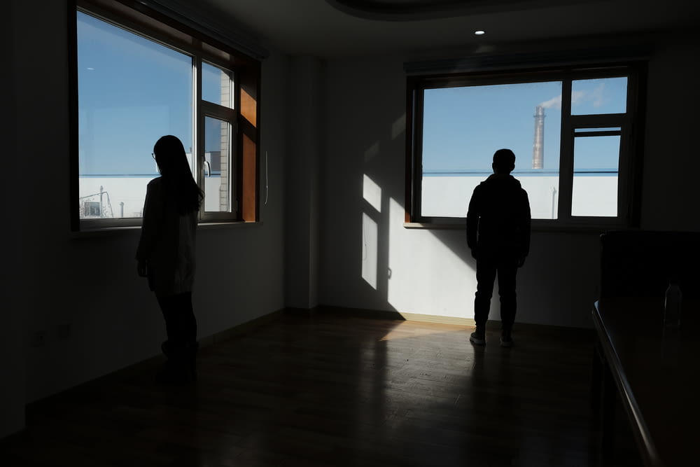 two people standing in dark room