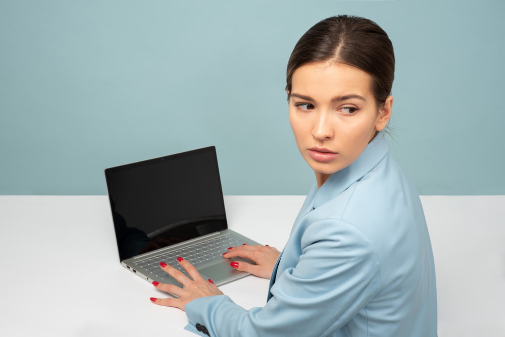 mulher usando laptop e olhando para o lado