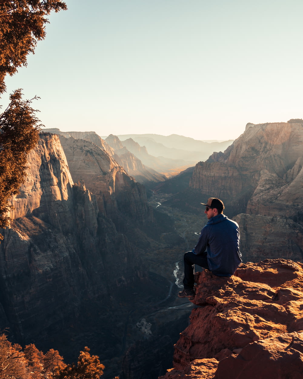 Mann sitzt tagsüber auf der Klippe des Canyons