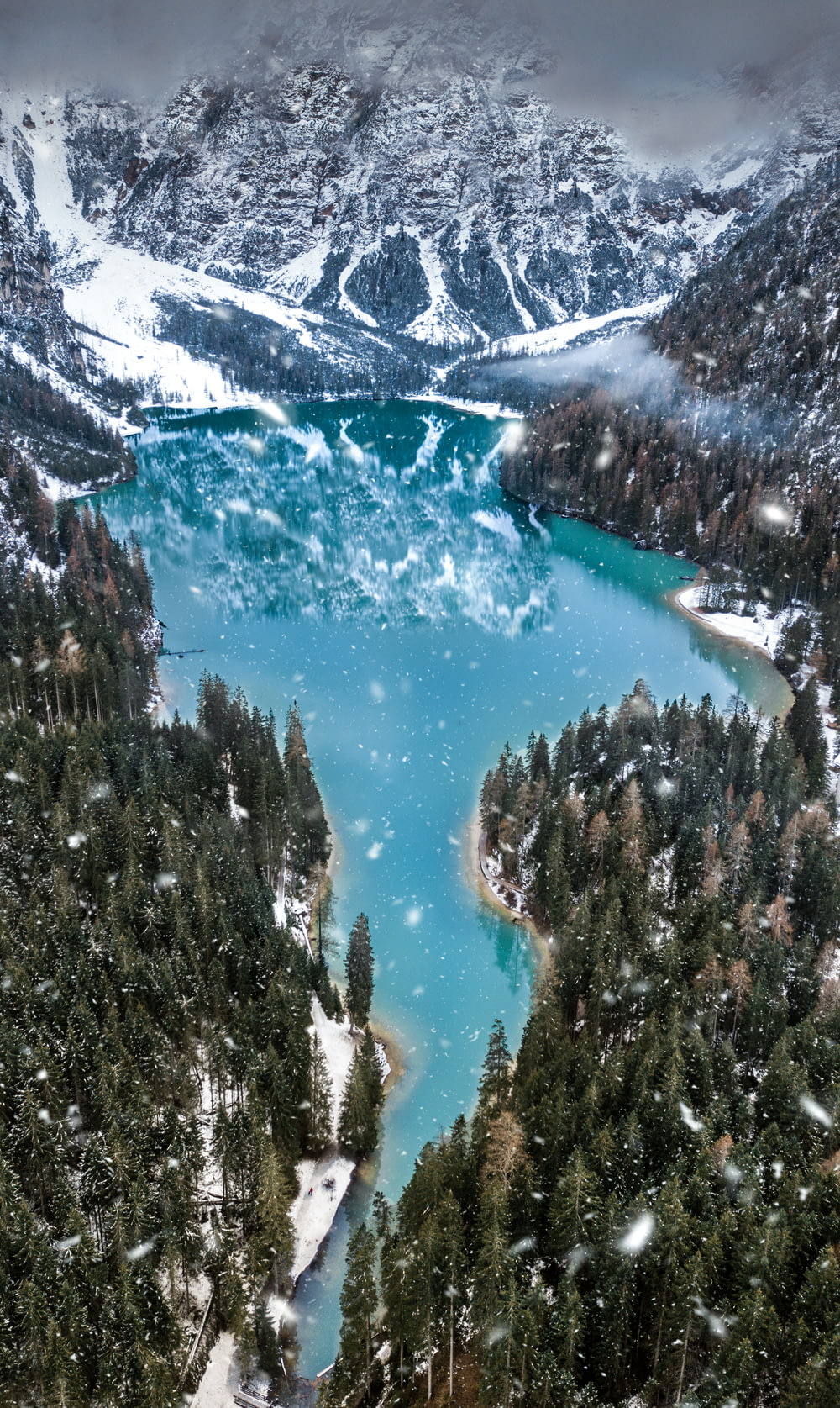 aerial photo of snow covered mountain near body of water