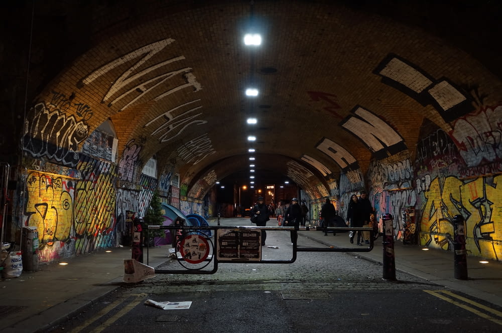 people siting inside concrete tunnel at night