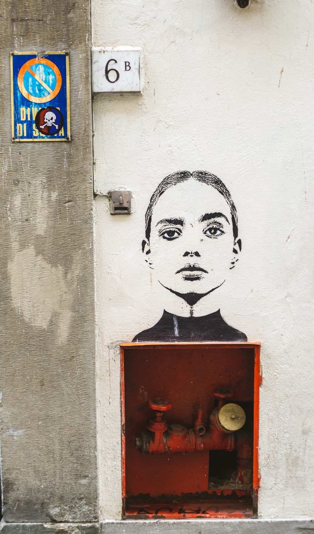 woman looking straight graffiti above red metal pump